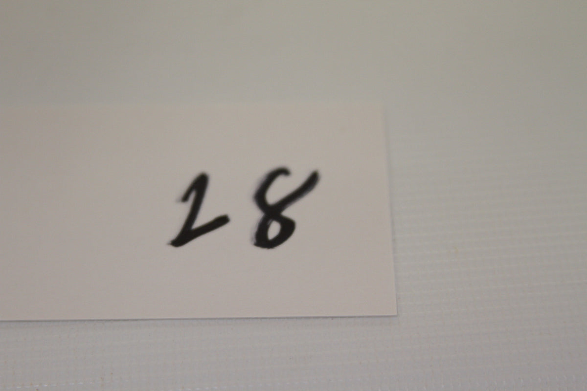 Handwritten number 28 on a small white card