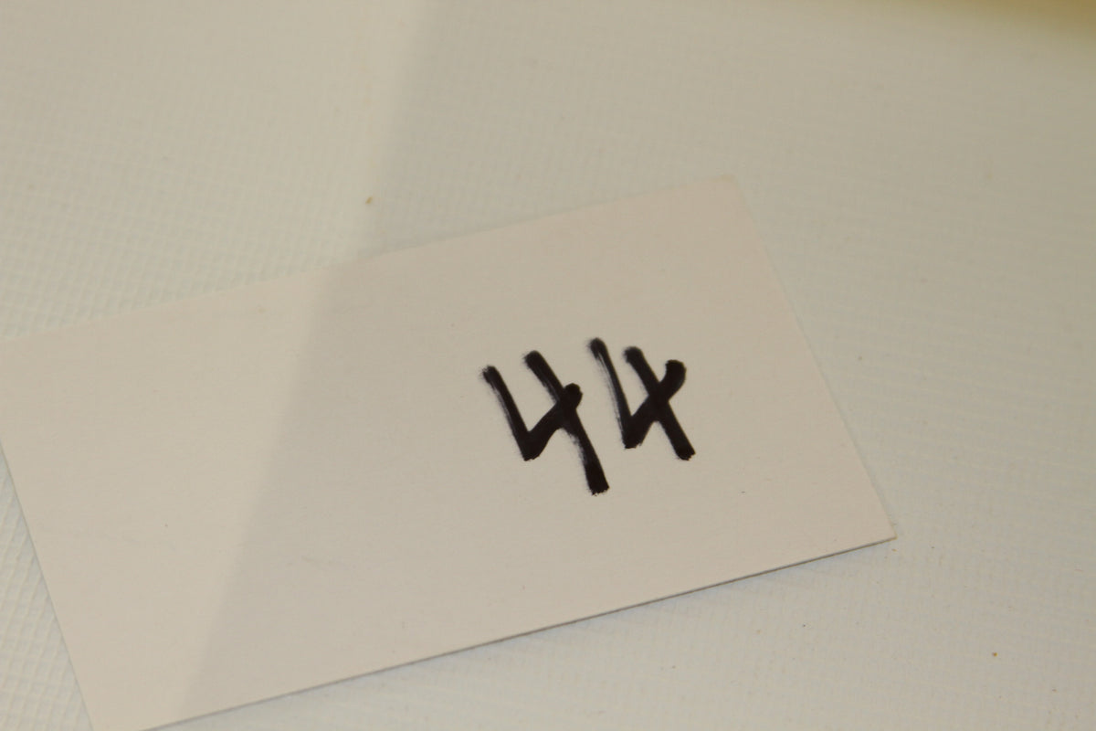 White card with number 44 written in black marker