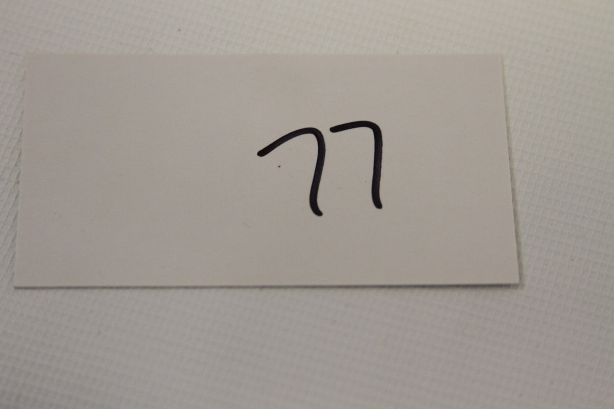 White card with handwritten number 77