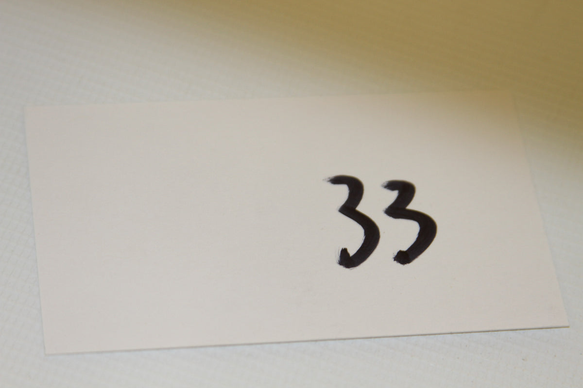 White card with handwritten number 33