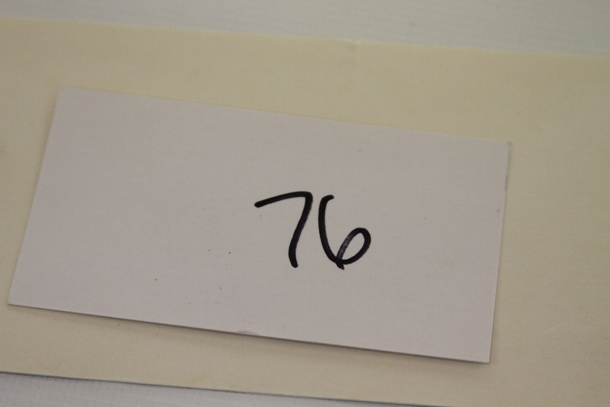 Handwritten number 76 on white card from product lot