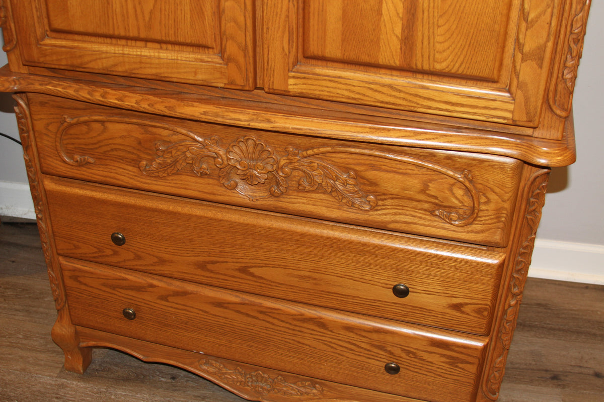 Close-up of carved details and drawers on oak armoire
