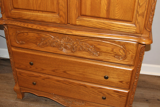 Close-up of carved details and drawers on oak armoire