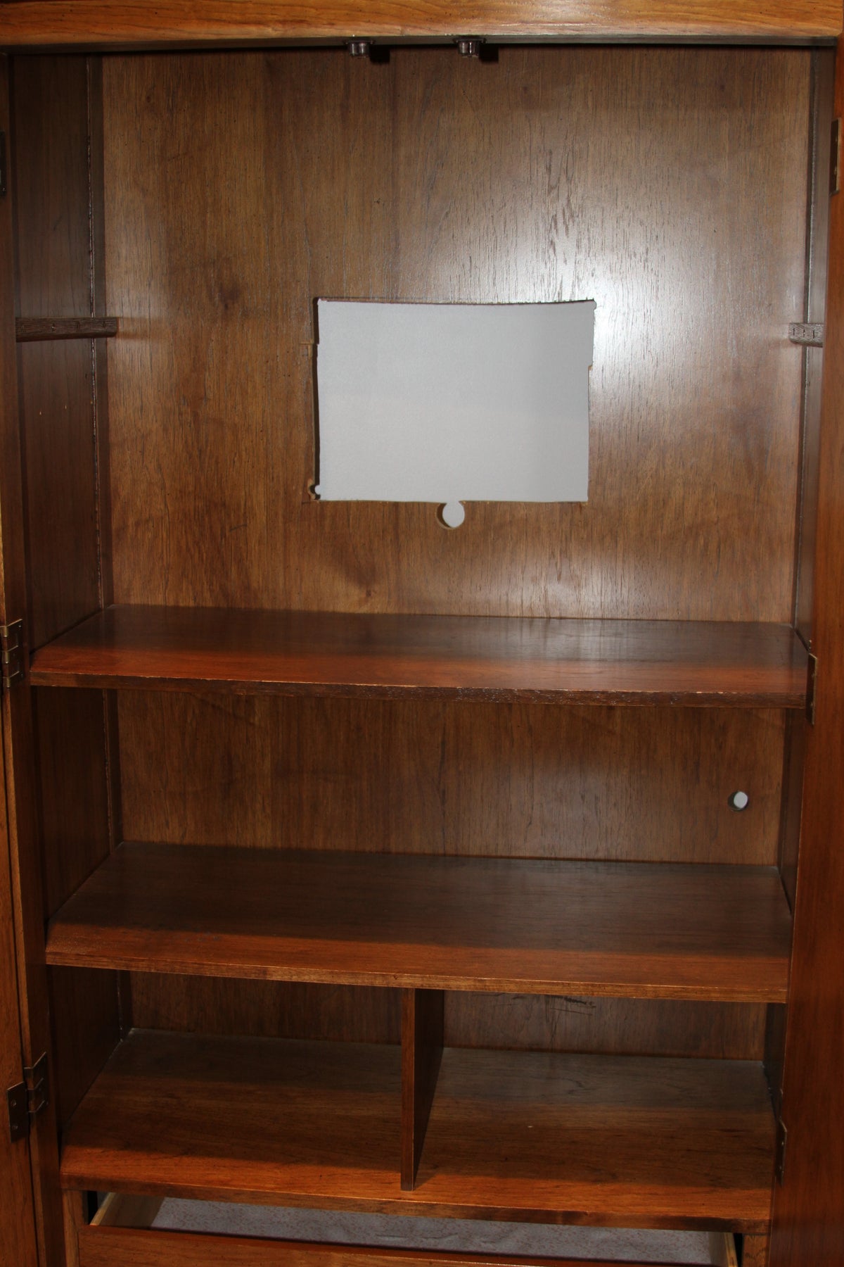 Interior shelves and cable cutout of wooden armoire