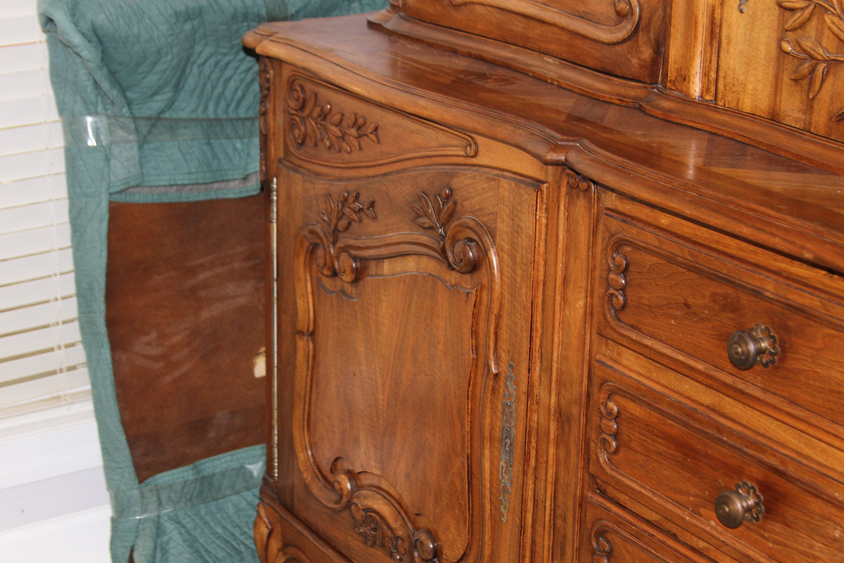 Side view of buffet showing hand-carved cabinet doors and brass hinge