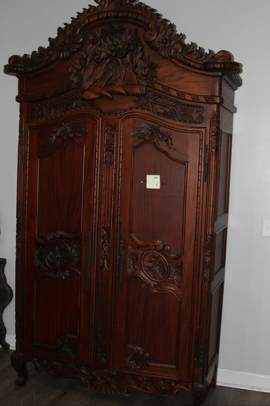 Elaborately carved mahogany armoire with floral and bird motifs