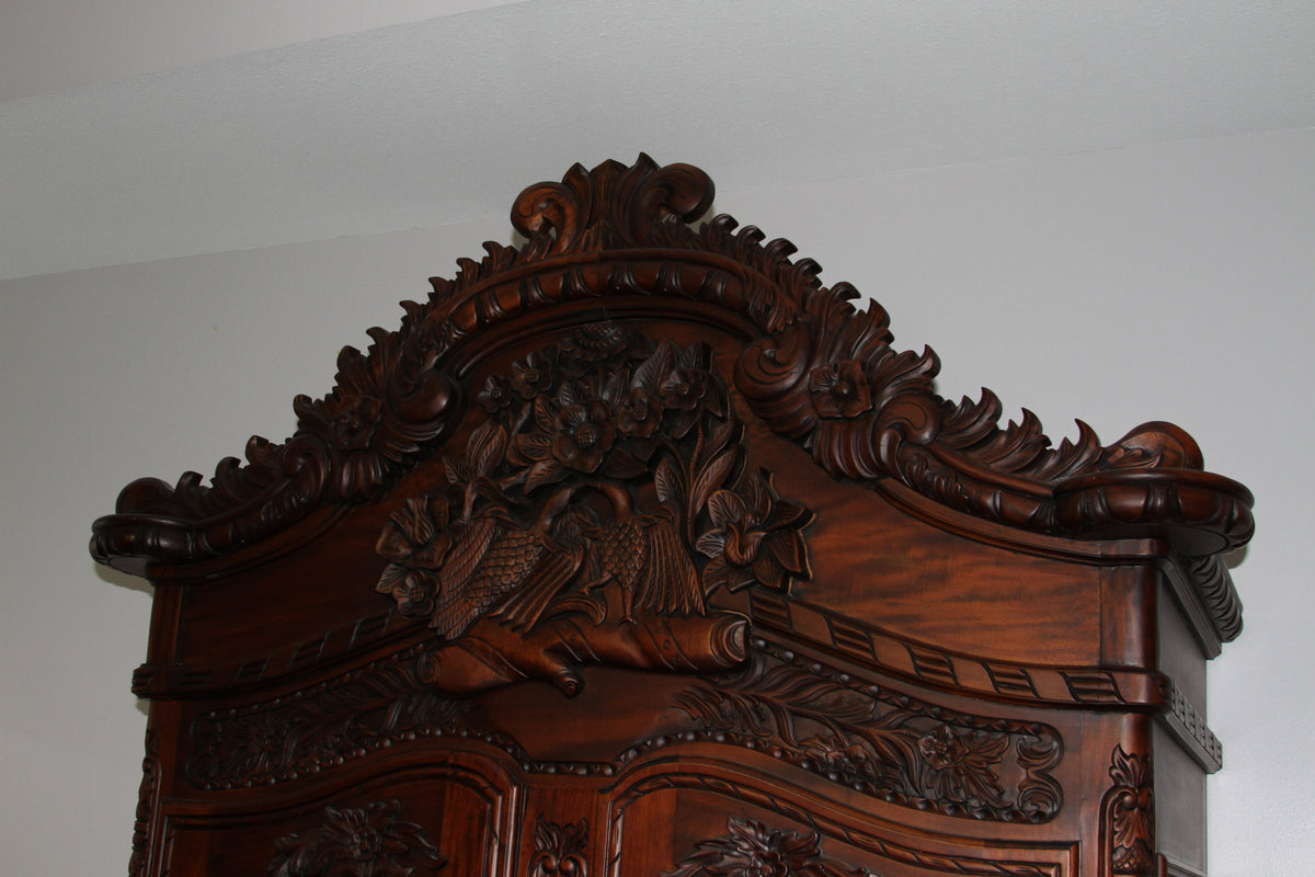 Close-up of ornate crest with floral carvings on armoire