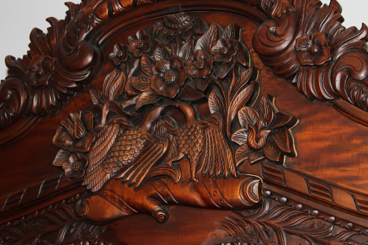 Detailed view of carved birds and flowers on armoire crest