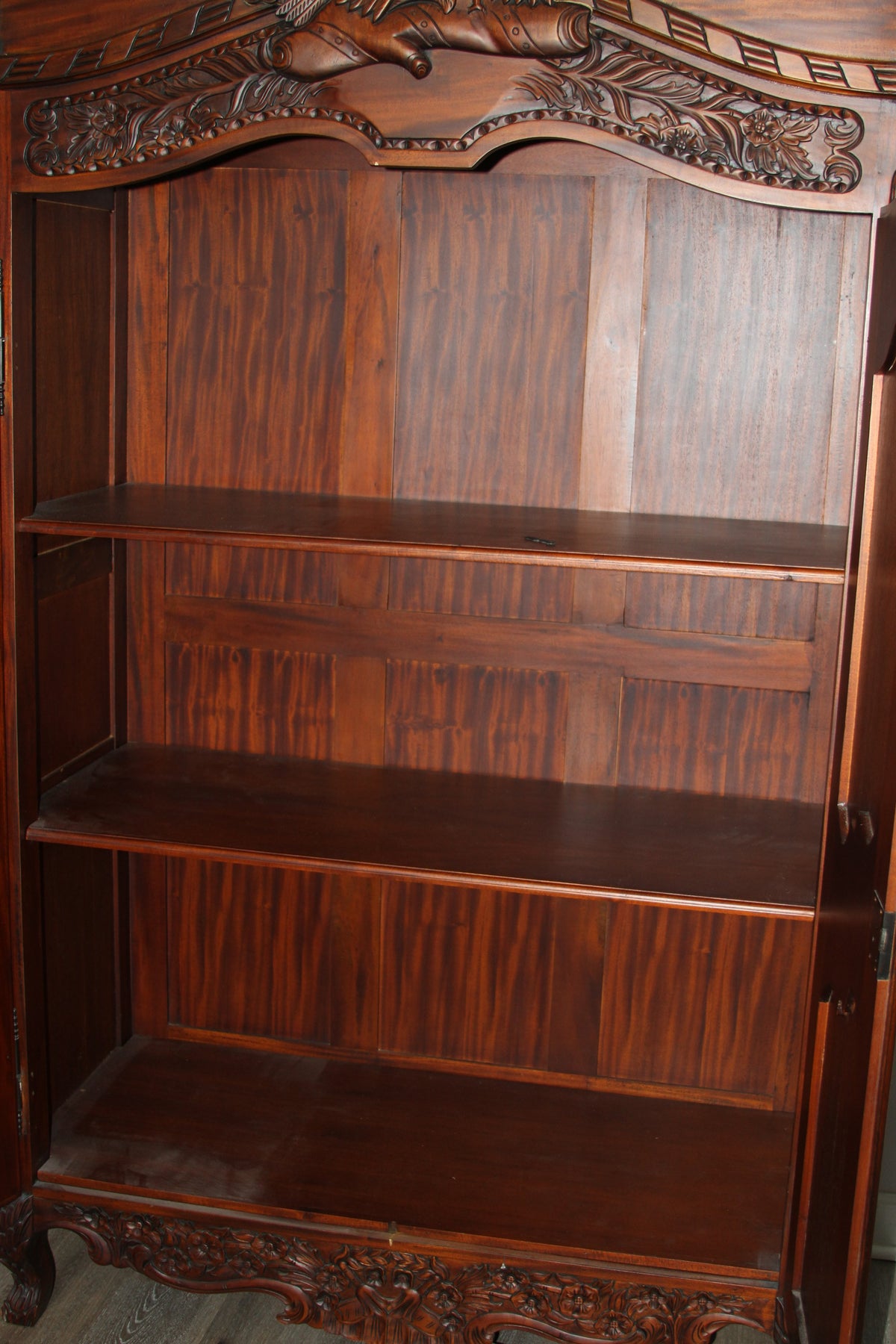 Interior of armoire with three spacious wooden shelves