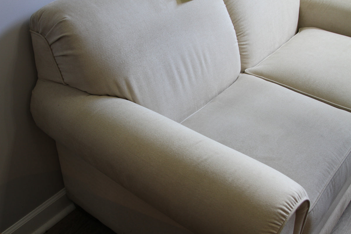 Close-up of left armrest and cushion on La-Z-Boy cream loveseat