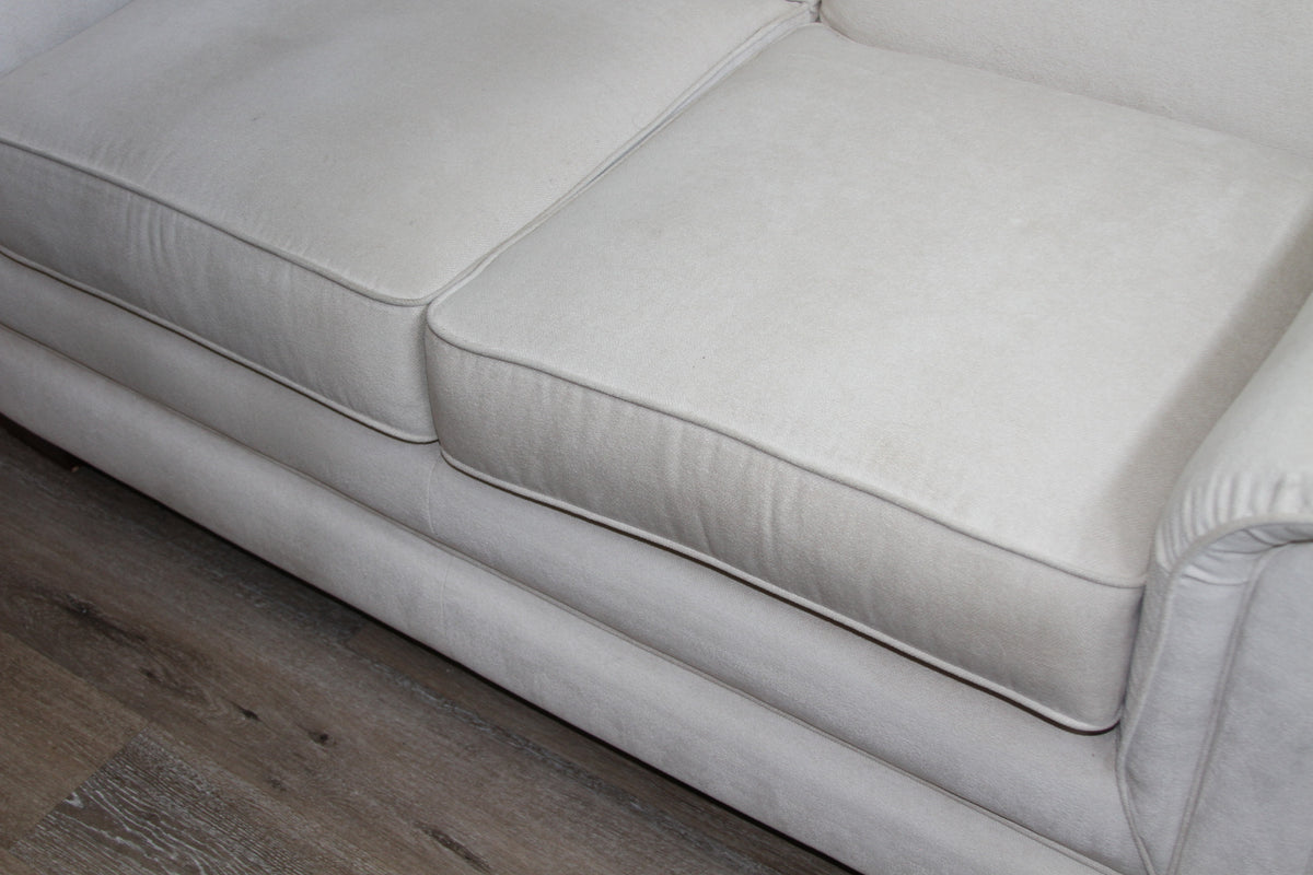 Front view of cream loveseat seat cushions and base on wood flooring