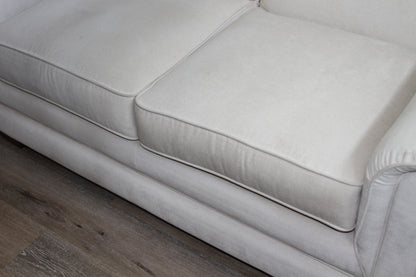 Front view of cream loveseat seat cushions and base on wood flooring