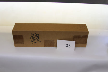 Closed brown cardboard box with handwritten 'Topps 1986' label and a card displaying the number 23