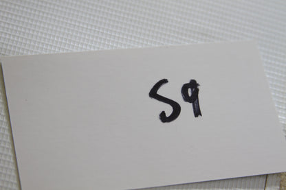 White card with handwritten 'S9'