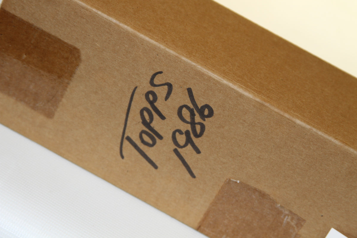 Close-up of 'Topps 1986' handwritten label on brown box