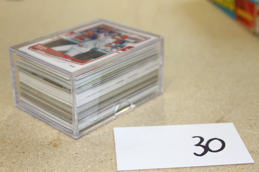 Angled view of baseball cards in clear plastic case next to a numbered card