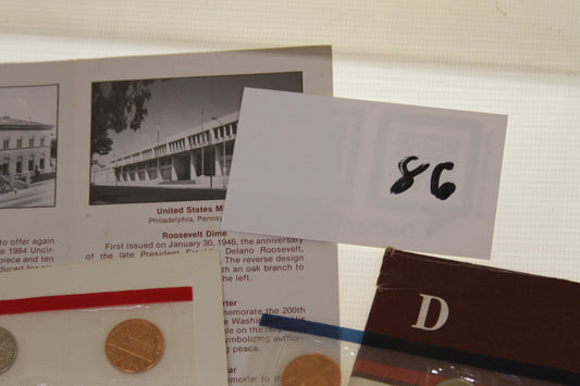 Closeup of informational card and handwritten label next to coin set