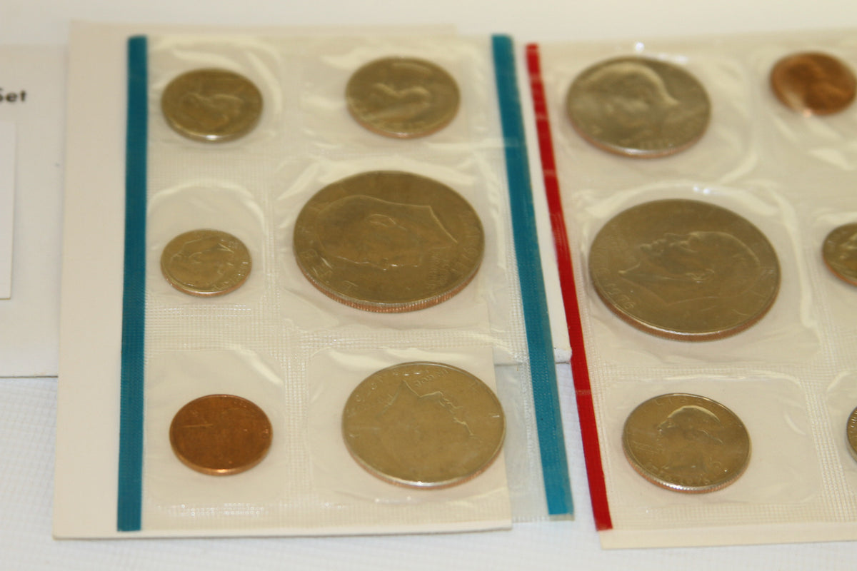 Close-up view of 1976 uncirculated coins in blue and red edged sleeves
