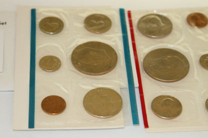 Close-up view of 1976 uncirculated coins in blue and red edged sleeves