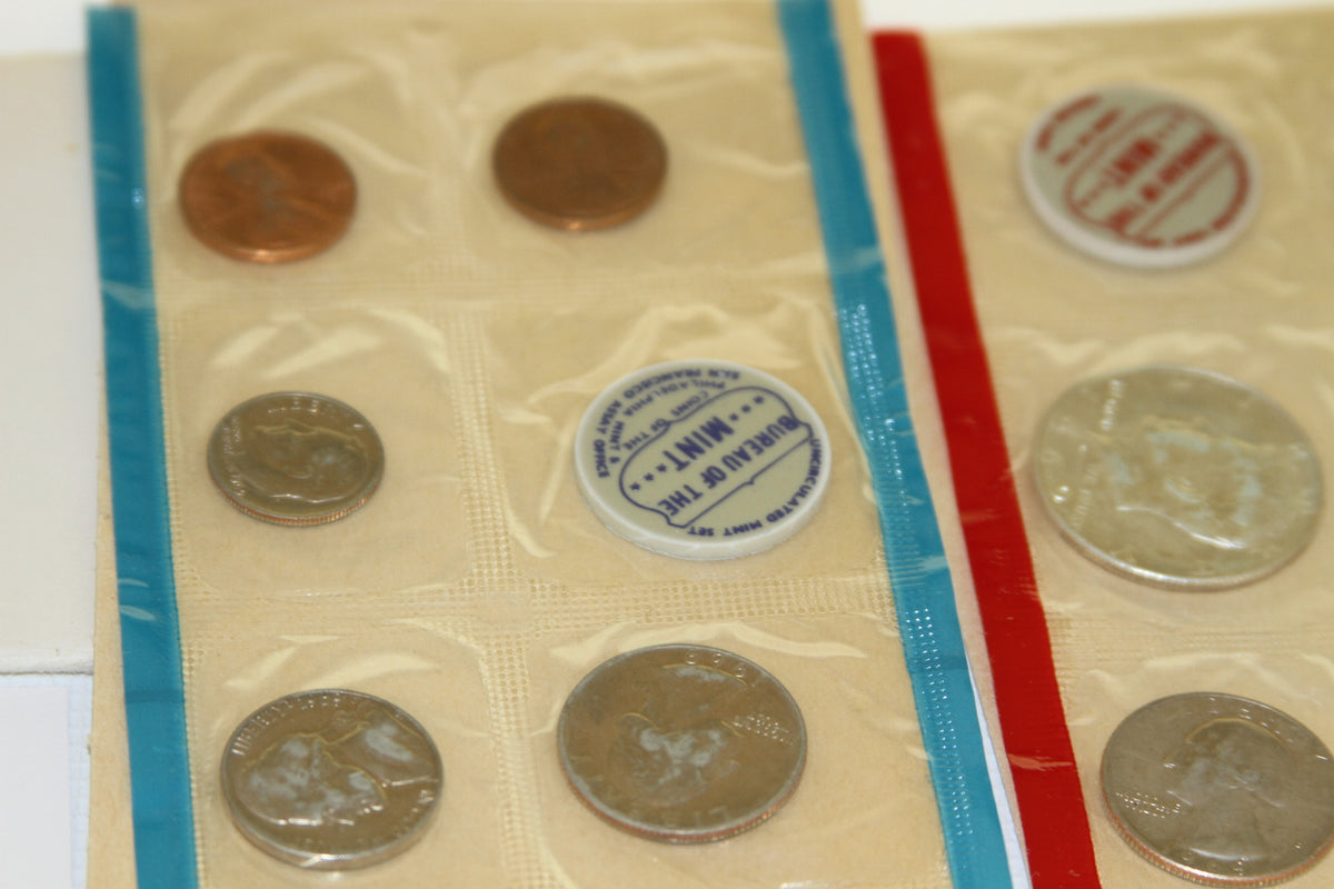Close-up of uncirculated coins and blue Bureau of the Mint token in mint packaging