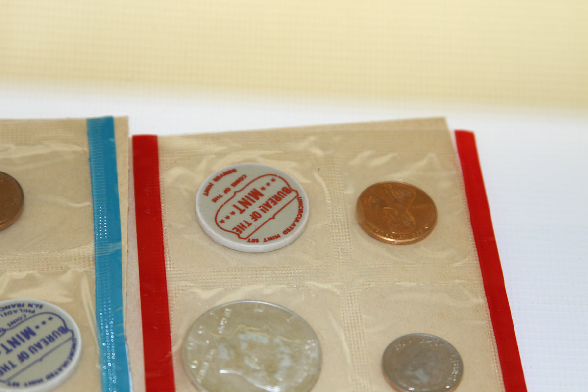 Detail of coins and red Bureau of the Mint token in original cellophane package