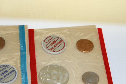 Detail of coins and red Bureau of the Mint token in original cellophane package