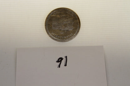 Top view of Pennsylvania Bicentennial commemorative coin near a card labeled 91