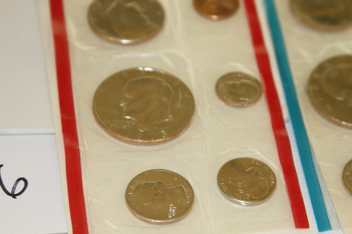 Detailed view of uncirculated coins in red-edged mint packaging from 1973 set