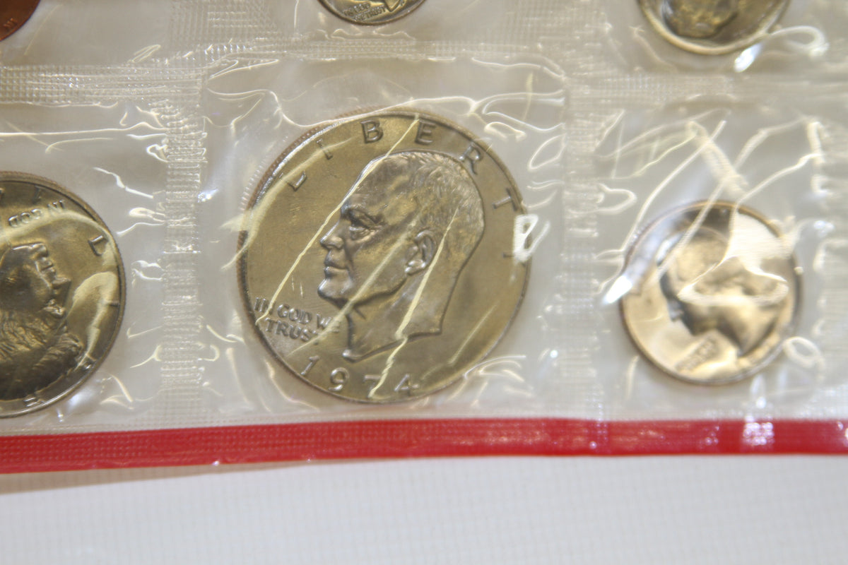 Detail of Eisenhower dollar and surrounding coins in 1974 red-edged Mint packaging