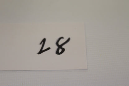 Handwritten number 28 on a small white card
