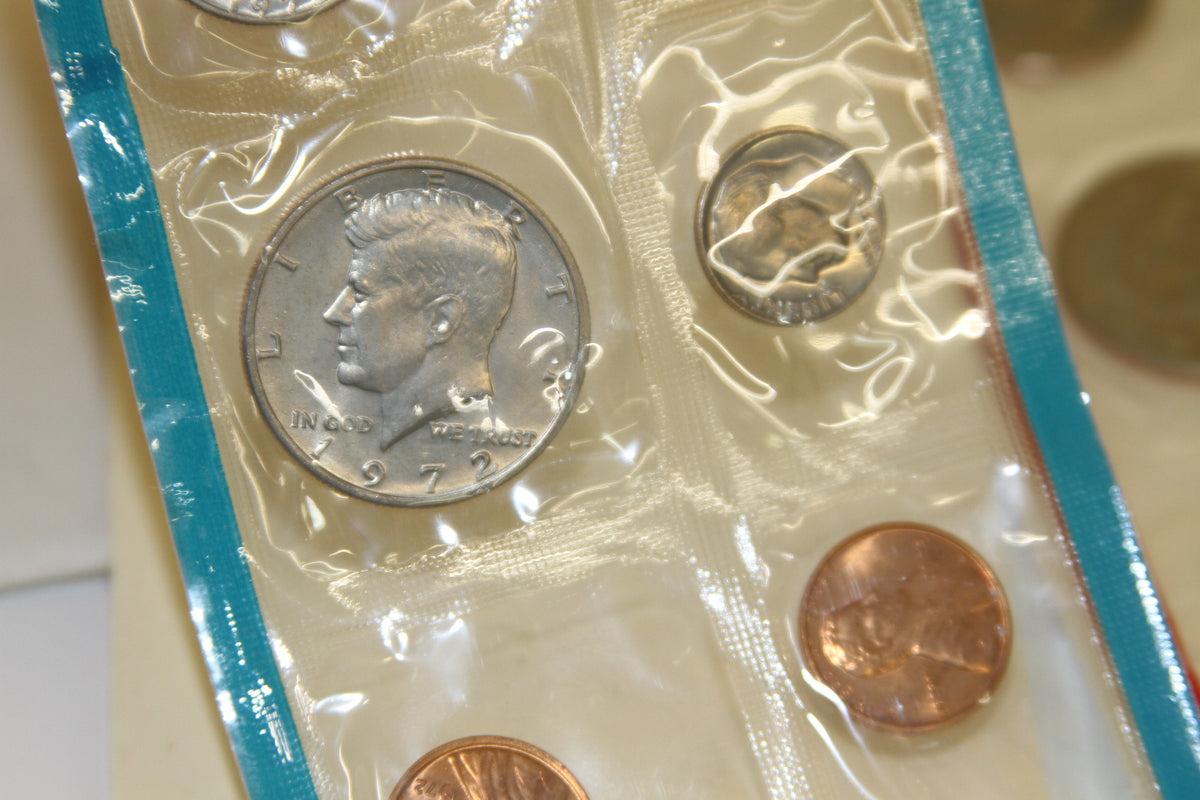 Detail of 1972 Kennedy half dollar, dime, and penny in blue edged sleeve