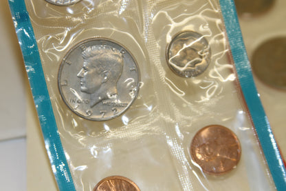 Detail of 1972 Kennedy half dollar, dime, and penny in blue edged sleeve