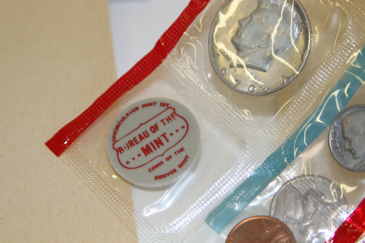 Close-up of red Bureau of the Mint medallion and 1970 Kennedy half dollar coin