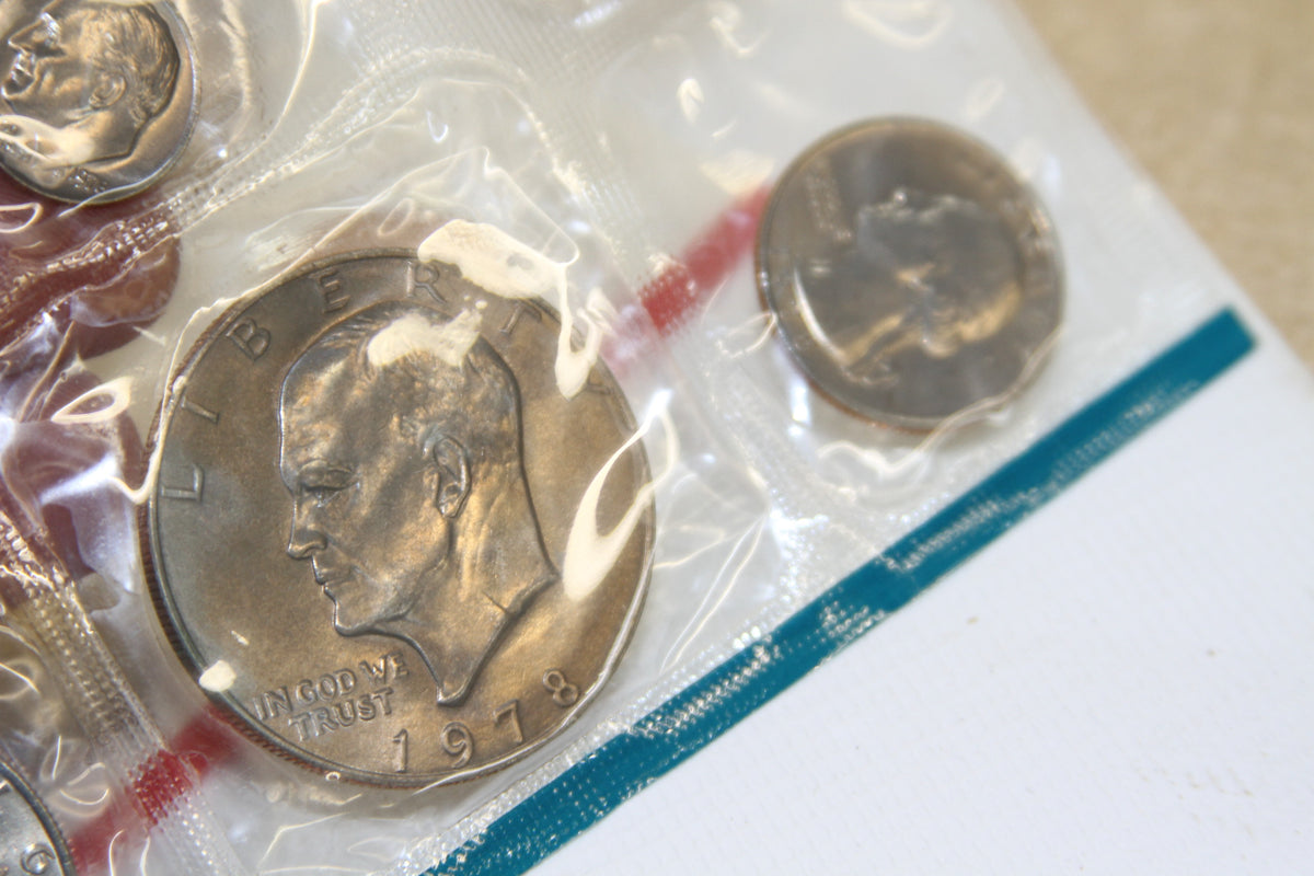 Close-up of Eisenhower dollar and other coins in original blue-edged U.S. Mint packaging