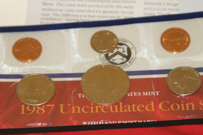 Lower section of coin set packaging showing coins and official logo