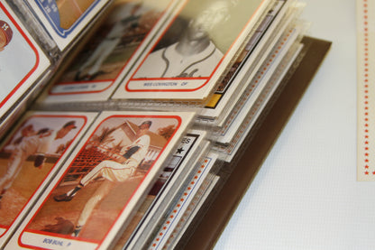 Several vintage baseball cards in protective sleeves within album