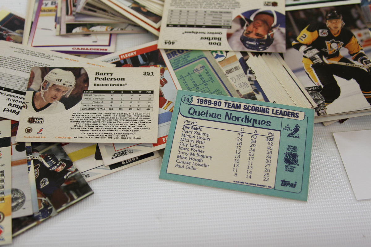 Selection of NHL card backs, focusing on Barry Pederson and a blue Quebec Nordiques statistics card.