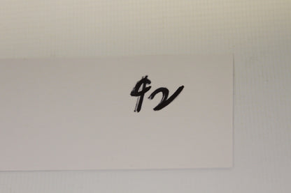 Handwritten white card with dollar sign and notation
