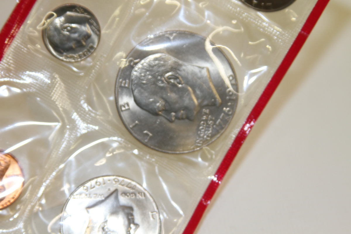 Obverse of 1976 Kennedy half dollar and other U.S. coins in red sleeve