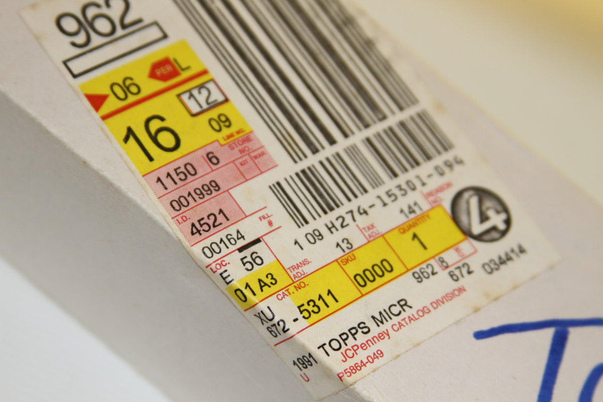 Detailed close-up of shipping and barcode sticker on Topps Micro box