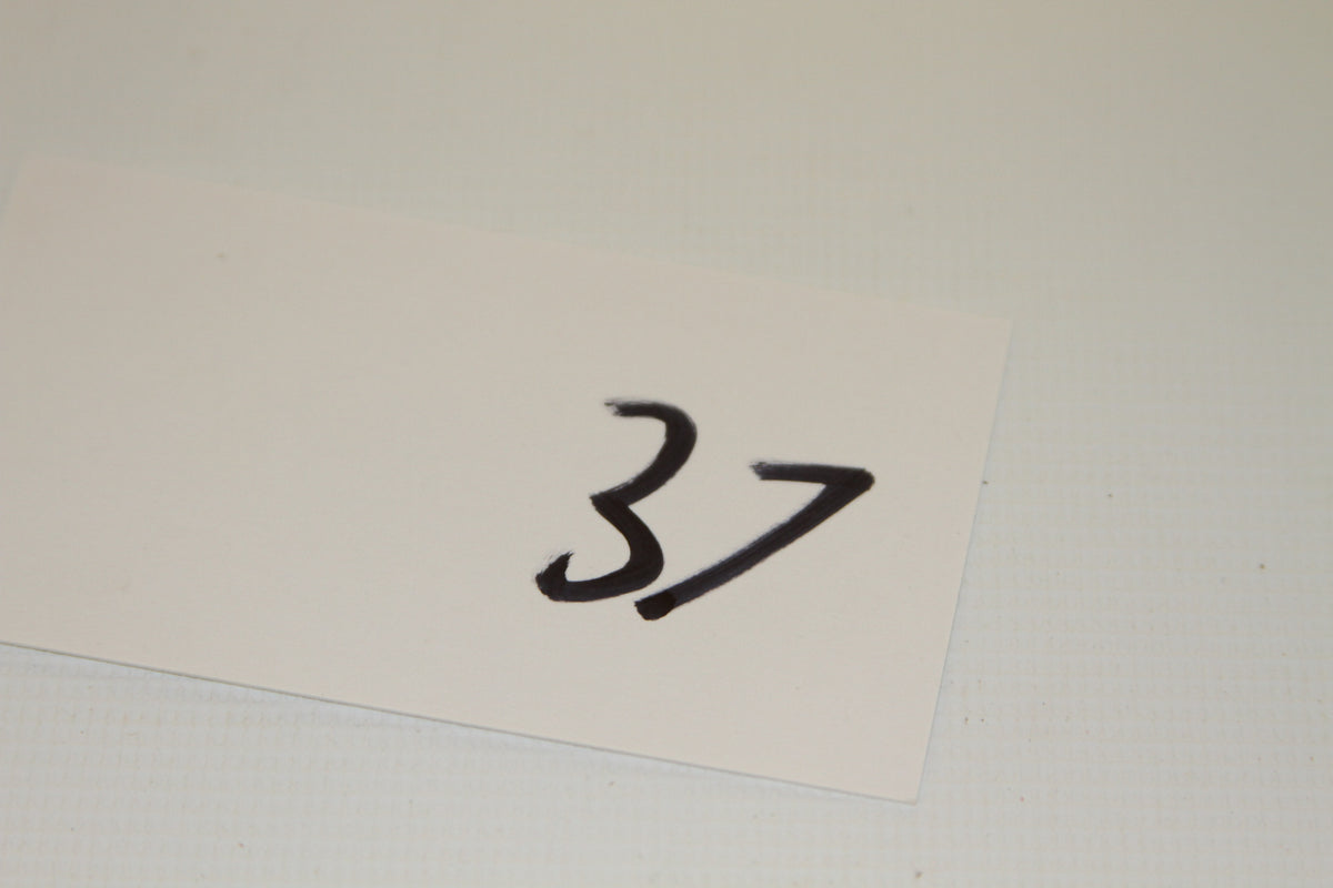 Paper card with handwritten number 37