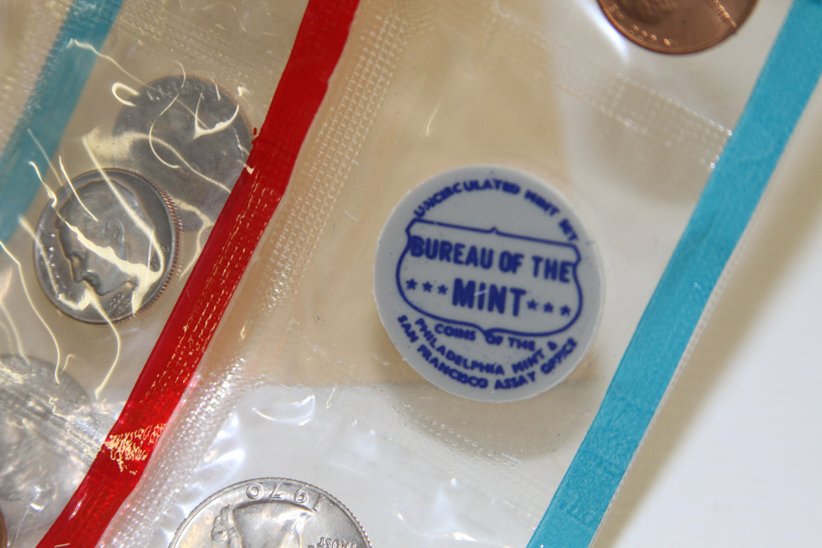 Close-up of blue Bureau of the Mint medallion and uncirculated coins