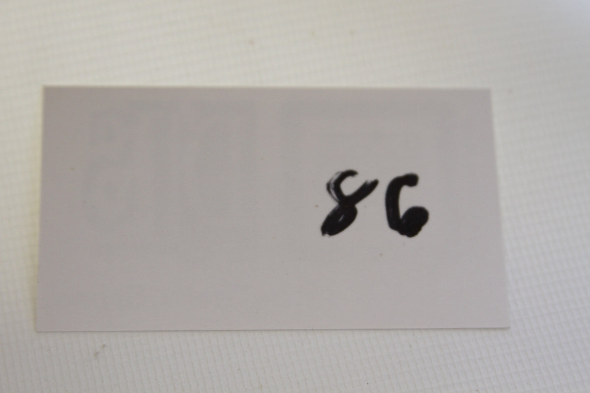 Handwritten number 86 on white card