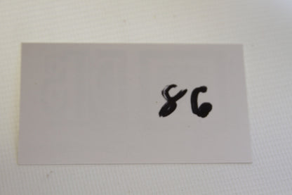 Handwritten number 86 on white card