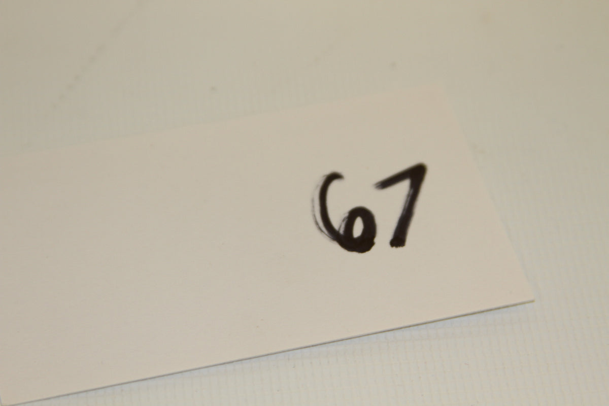 White card with handwritten number 67