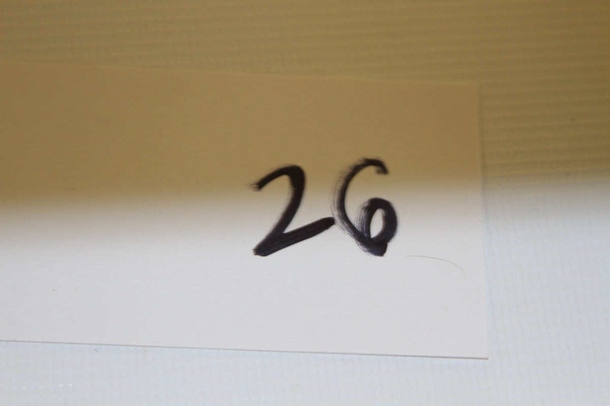 White card with number 26 handwritten in black marker