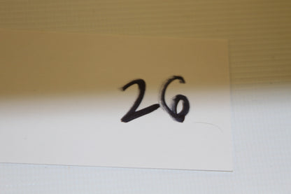 White card with number 26 handwritten in black marker
