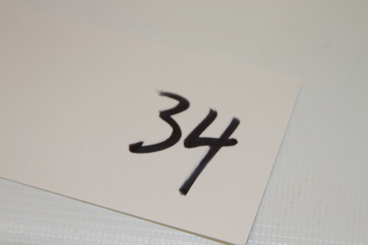 White card labeled with number 34 in black marker