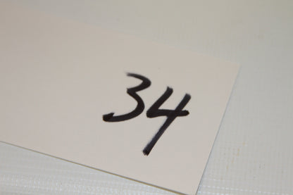 White card labeled with number 34 in black marker