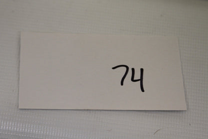 Card with number 74 written in black marker